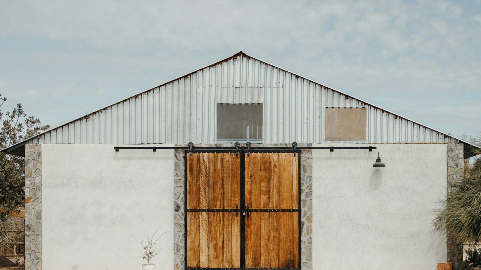 A charming rustic barn with wooden sliding doors, located in rural Mexico's picturesque countryside.