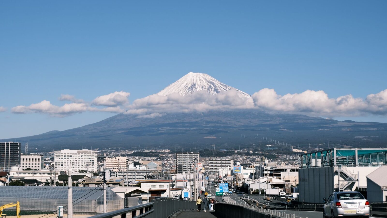 Majestic Mount Fuji rises over the urban landscape of Shizuoka, Japan, showcasing scenic beauty and city life.