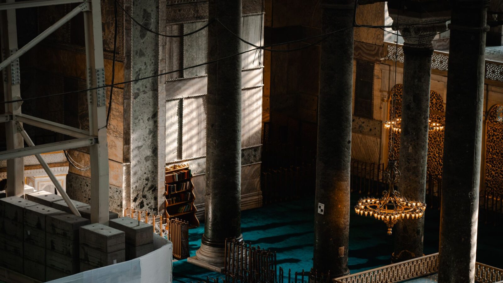 Sunlit view of historic mosque interior in Istanbul, Turkey, showcasing ornate columns.