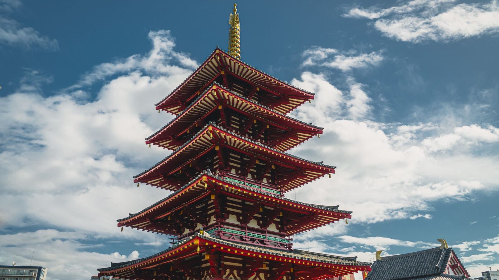 Capture the beauty of the iconic Shitennoji Temple pagoda set against a vibrant blue sky in Osaka, Japan.