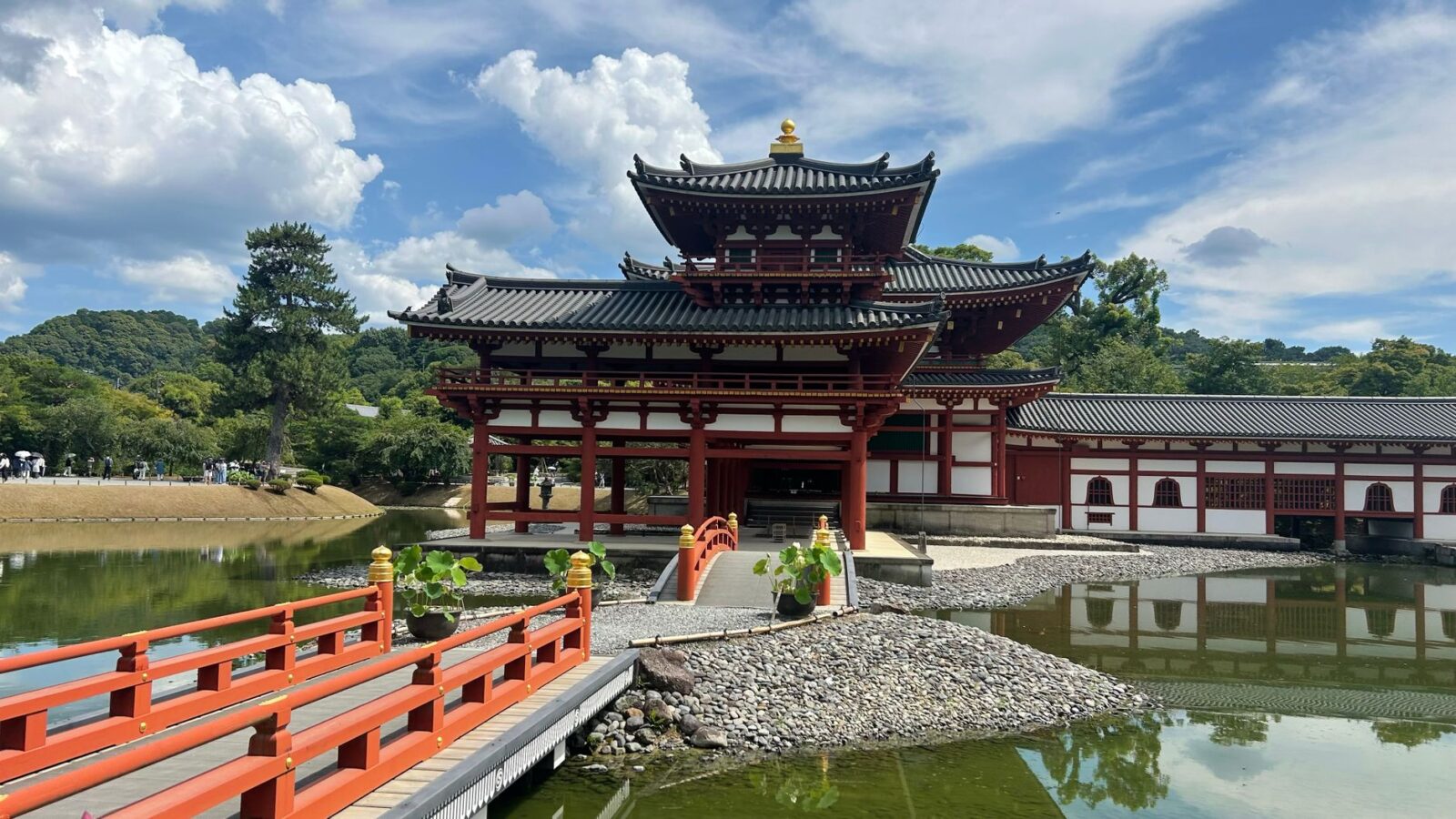 The Byodo-in Temple in Uji, Japan, captured under a bright blue sky, reflecting on the surrounding serene pond.