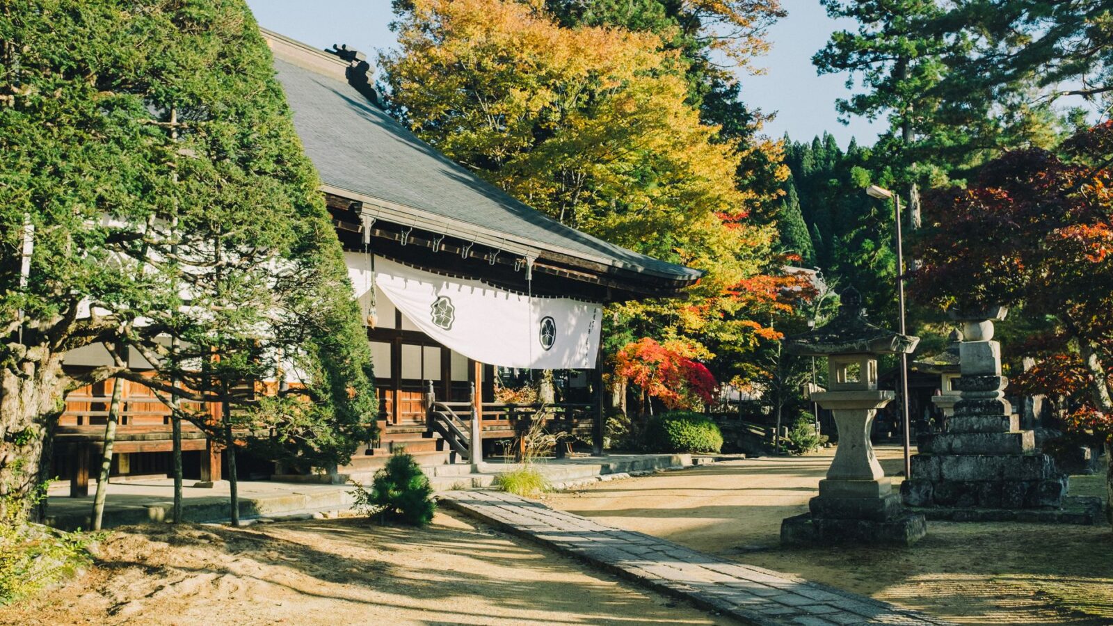 Peaceful Buddhist temple set against vibrant fall colors in Takayama, Japan.